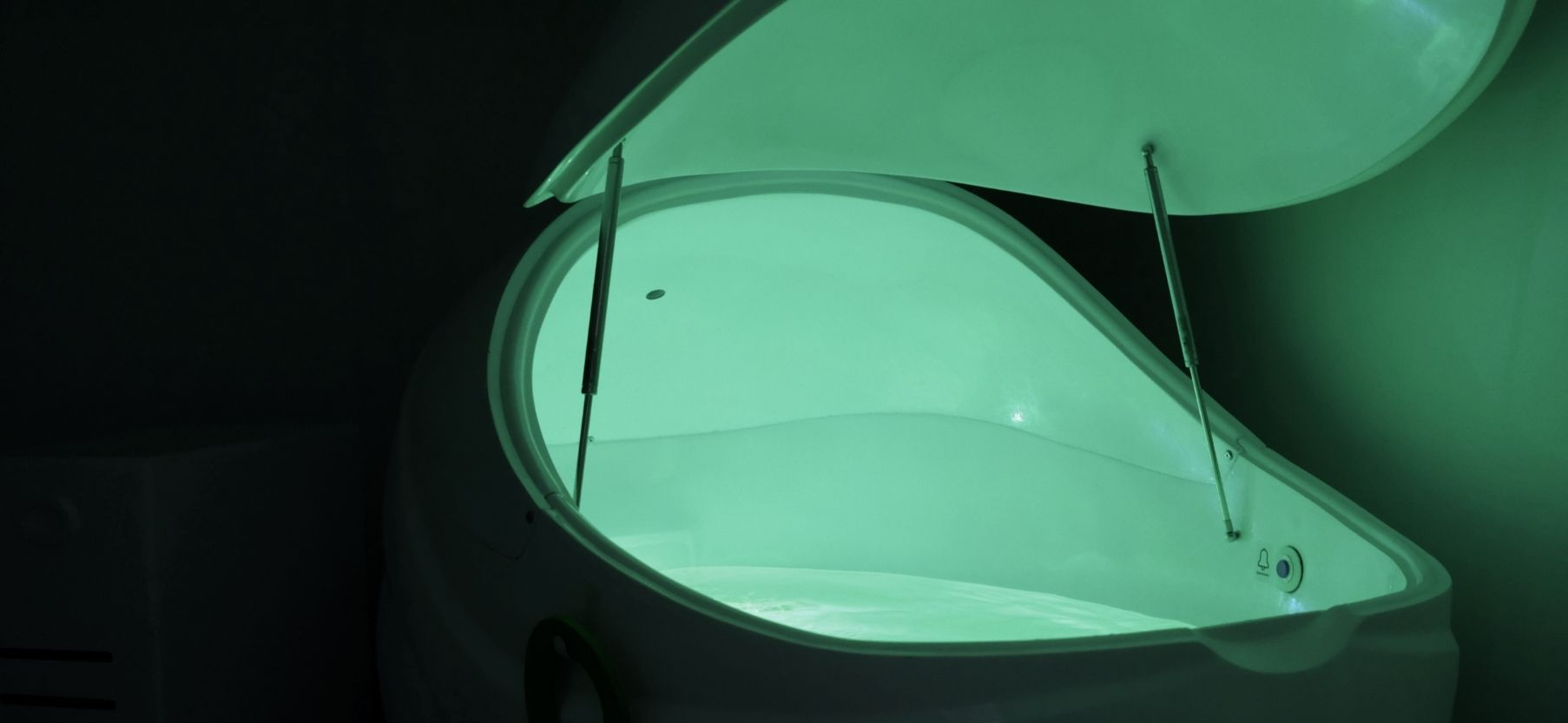 Beatrice Society - An open float tank with glowing green light